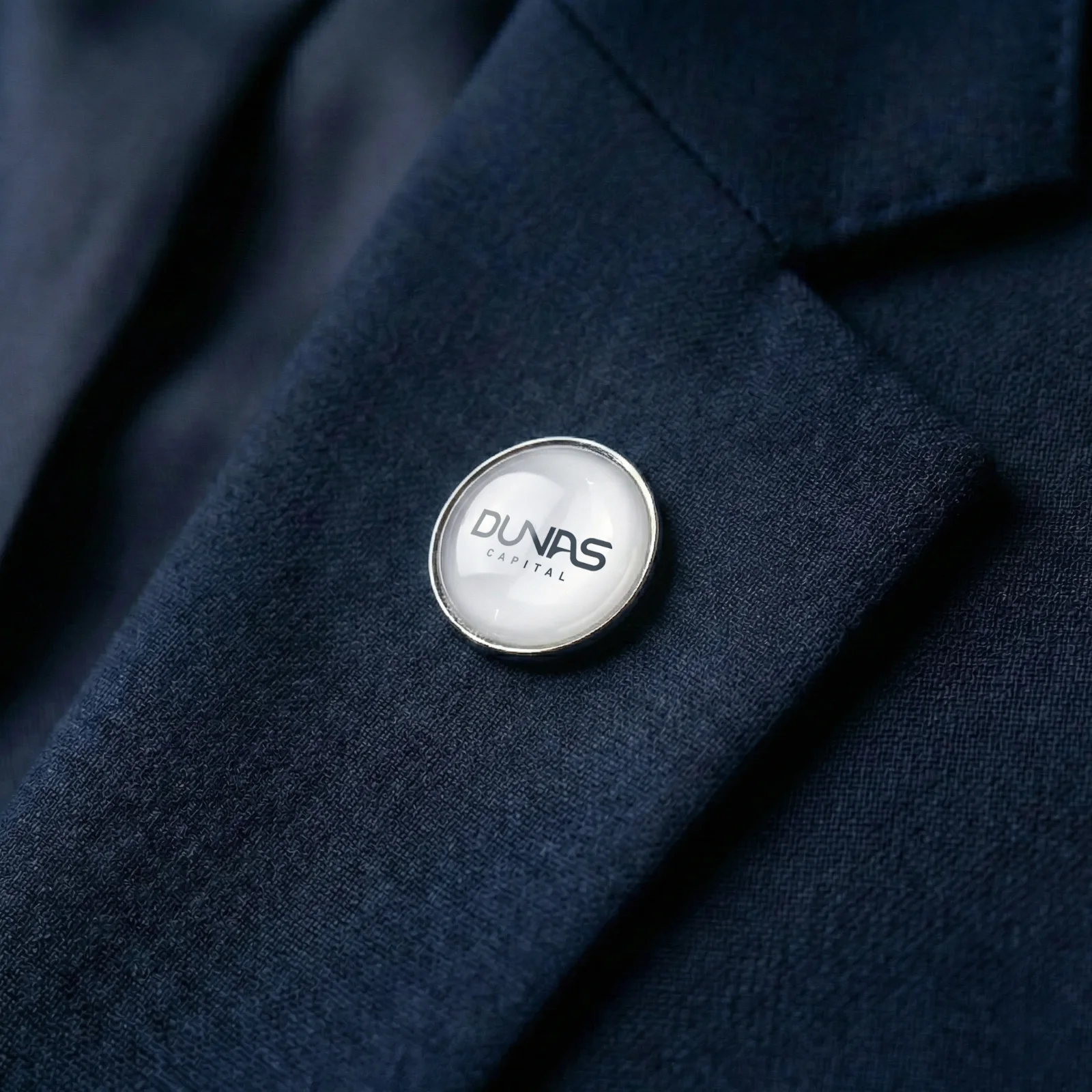 Broche da Dunas Capital na lapela de um terno azul
