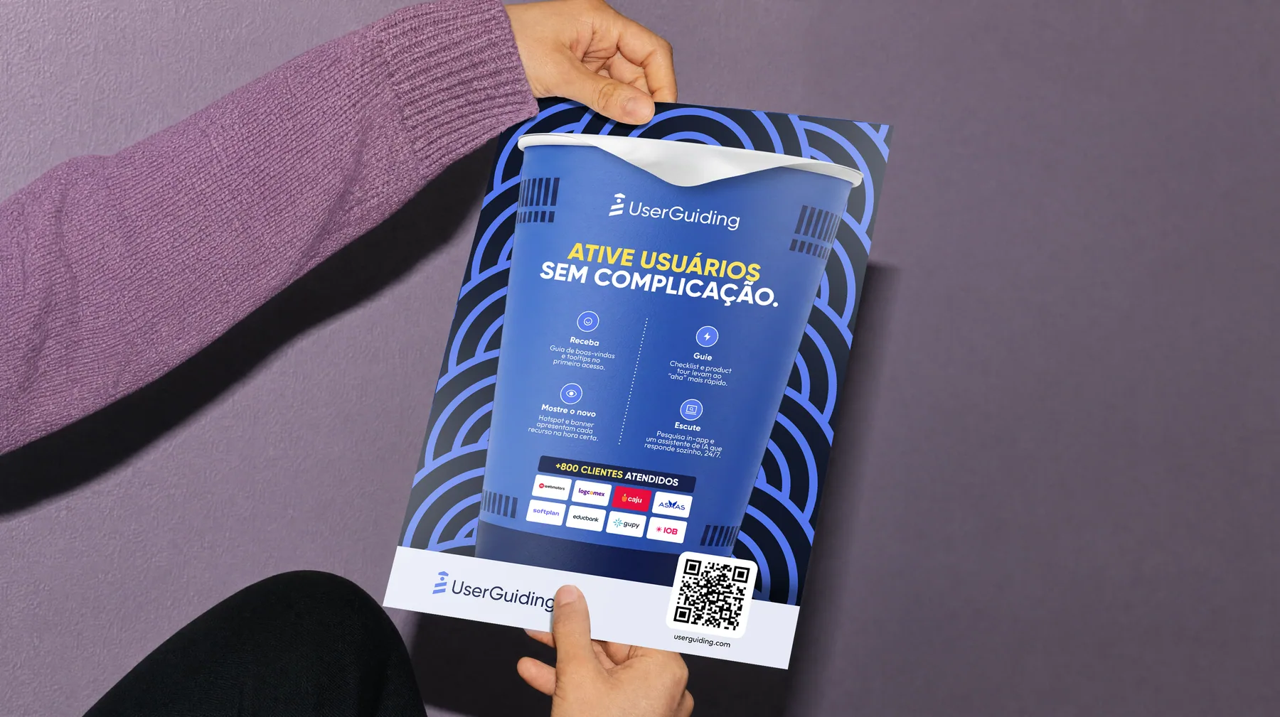 Flyer do modo de preparo da UserGuiding sendo segurado por uma pessoa
